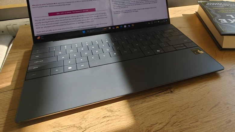 Upper corner view of the deck of the keyboard and Dell XPS 13 display.